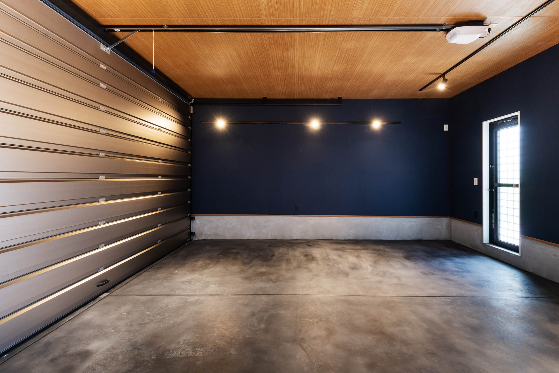 日本語: サブエントランスから眺めるガレージ空間 ｜ English: View of the garage from the secondary entrance