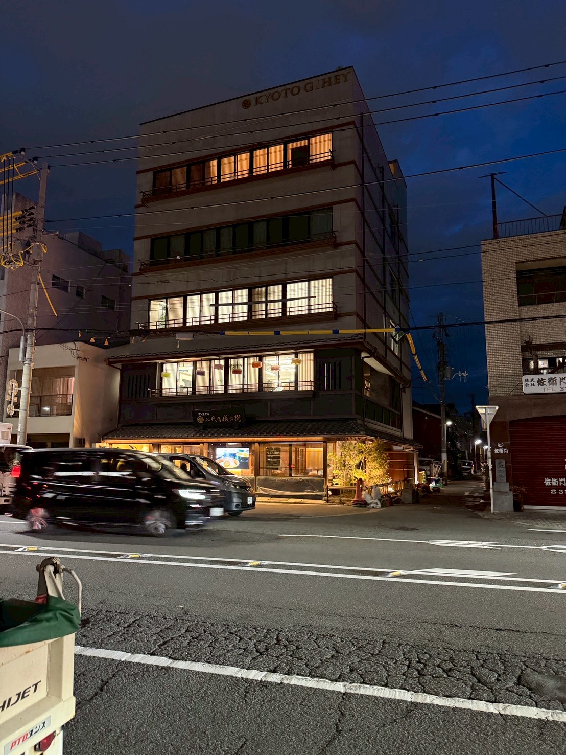 日本語: 1階から光が溢れる街と繋がるオフィスビル｜English: Office building connecting with the city, with light spilling from the first floor
